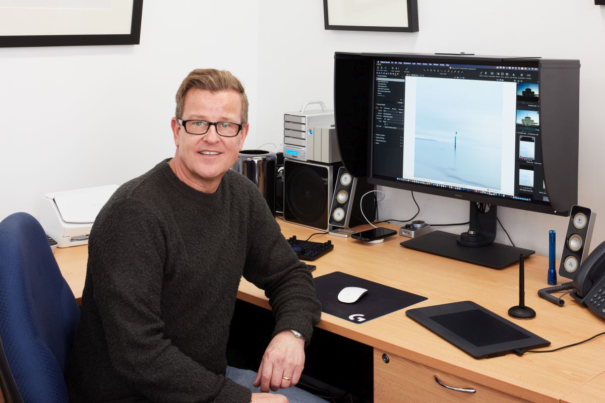 Ian van der Wolde sitting besides the SW321C photography monitor